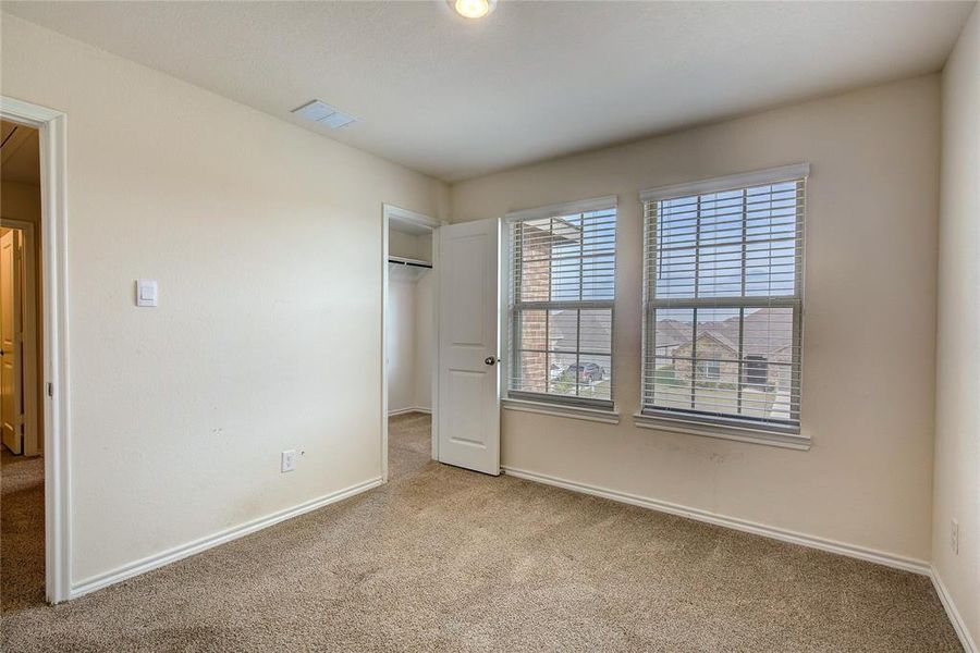 Unfurnished bedroom with a spacious closet and light carpet