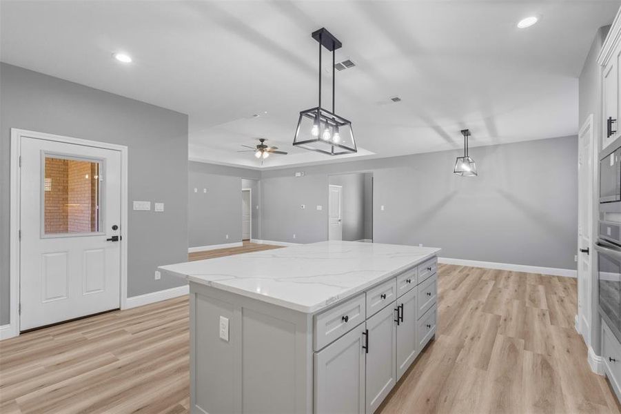 Kitchen featuring light wood-style flooring, hanging light fixtures, and a kitchen island
