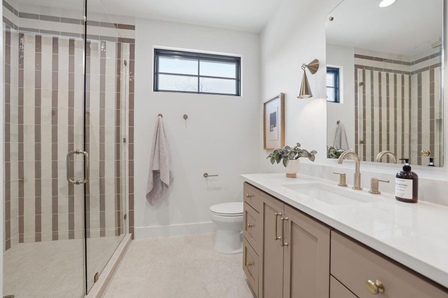 Full bathroom featuring vanity, a stall shower, and light tile patterned flooring