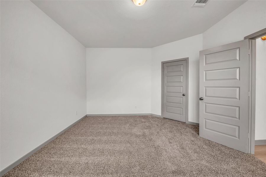 Empty room featuring light colored carpet and baseboards