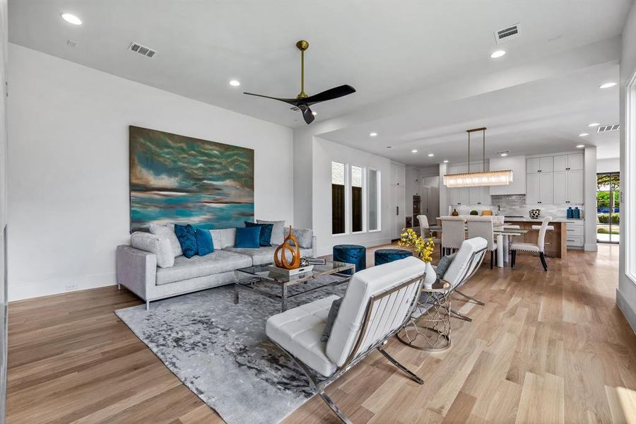 Living room with light hardwood / wood-style flooring and ceiling fan