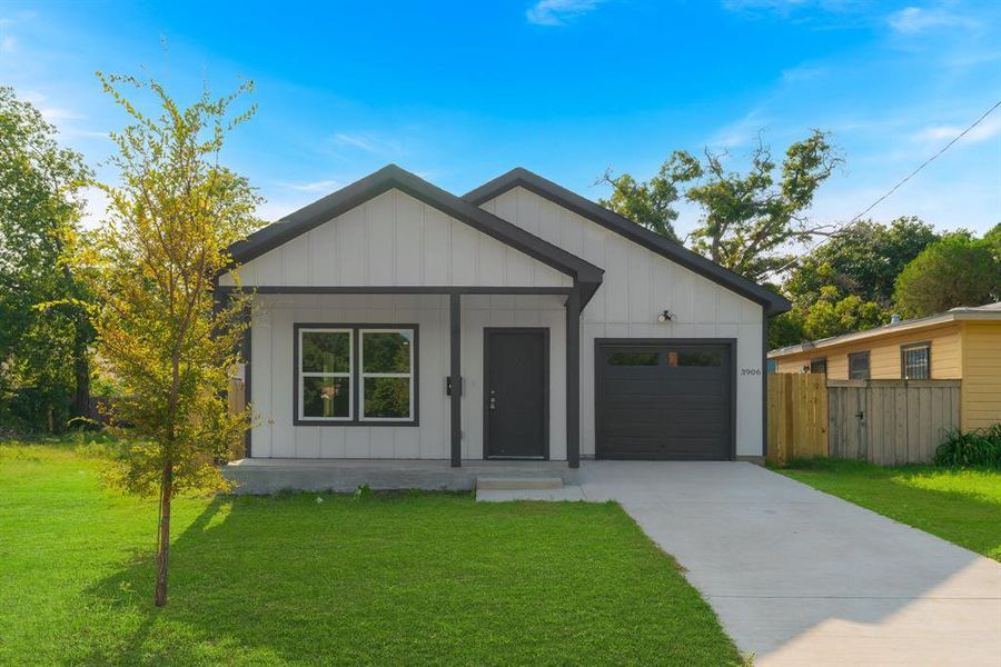 Modern farmhouse featuring a garage and a front yard