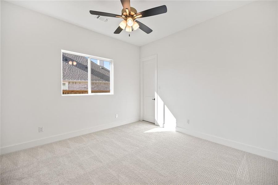 Carpeted spare room with baseboards and a ceiling fan Carpeted spare room with baseboards and a ceiling fan