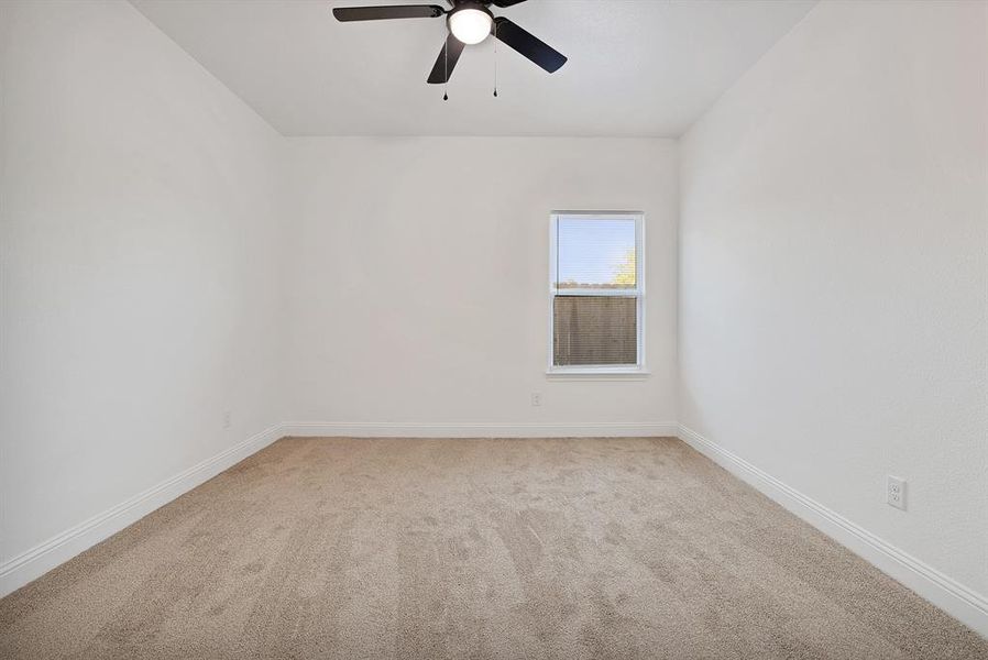 Carpeted empty room with ceiling fan