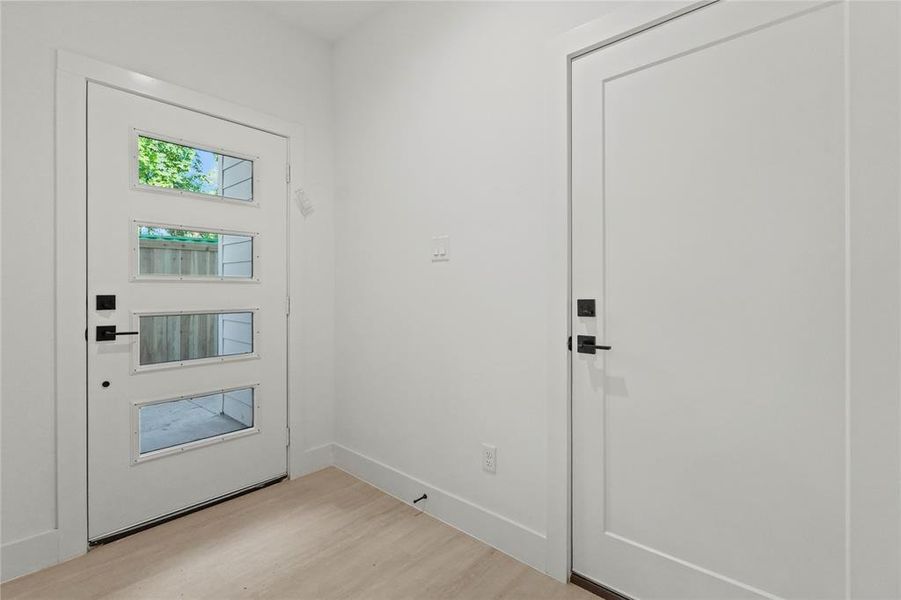 Foyer entrance featuring light wood-style flooring and baseboards Foyer entrance featuring light wood-style flooring and baseboards