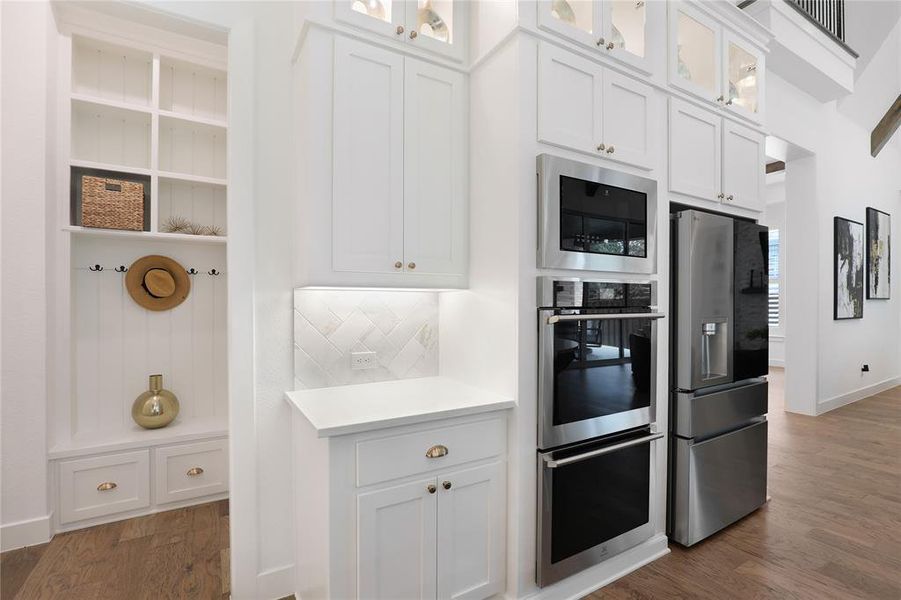 Integrated stainless steel appliances, including a built-in microwave, double oven, and refrigerator