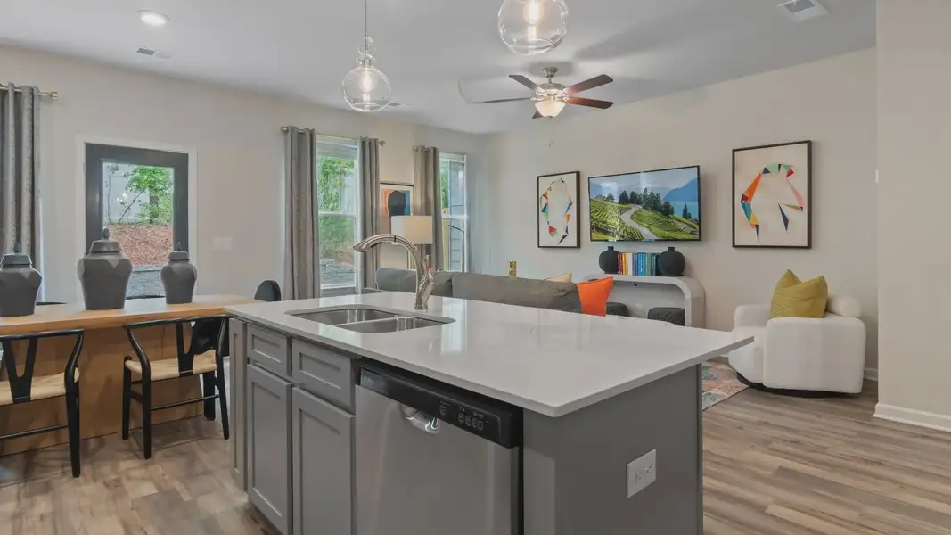 Decorated kitchen island with nearby dining area and gathering room