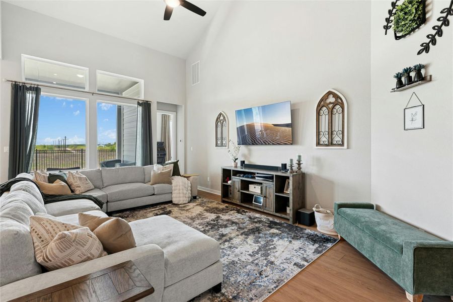 Living room with wood finished floors, lofted ceiling, and ceiling fan