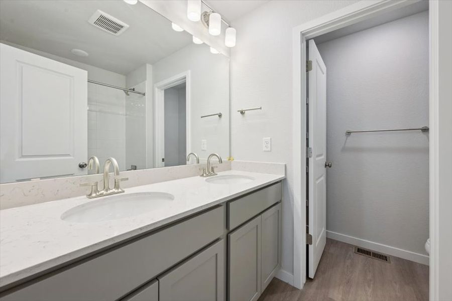 A bathroom with a sink and a shower unit. A bathroom with a sink and a shower unit.