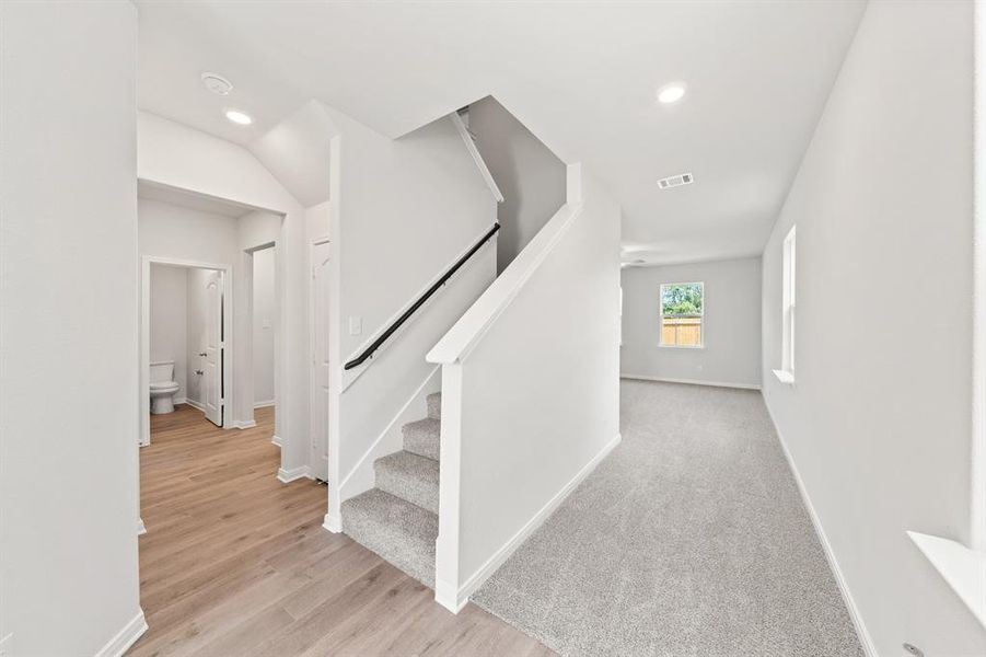 Staircase featuring recessed lighting, baseboards, visible vents, and wood finished floors