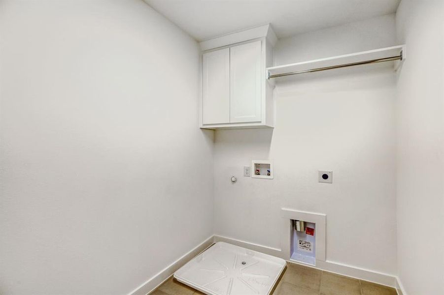 Laundry room with gas dryer hookup, electric dryer hookup, hookup for a washing machine, cabinet space, and light tile patterned floors