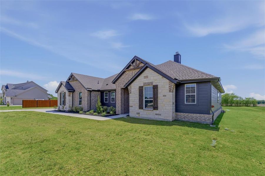 Exterior featuring stone and brick facade, dark siding, gabled rooflines, and decorative wood window shutters Exterior featuring stone and brick facade, dark siding, gabled rooflines, and decorative wood window shutters