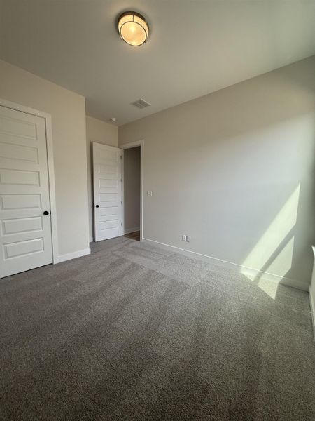 Unfurnished bedroom with carpet flooring and baseboards
