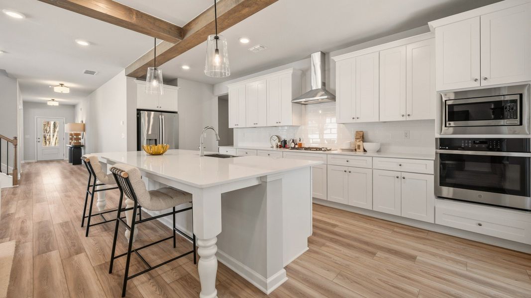 Kitchen with tile backsplash, quartz countertops, and pendant lighting Kitchen with tile backsplash, quartz countertops, and pendant lighting