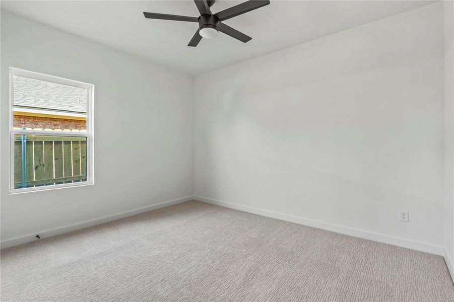 Carpeted spare room featuring baseboards and ceiling fan Carpeted spare room featuring baseboards and ceiling fan