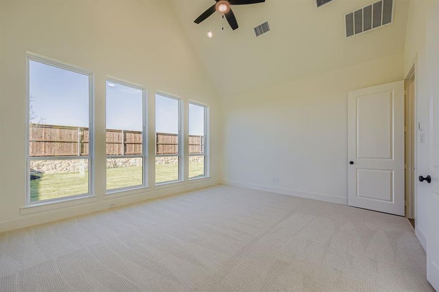 Spare room with high vaulted ceiling, light carpet, and ceiling fan