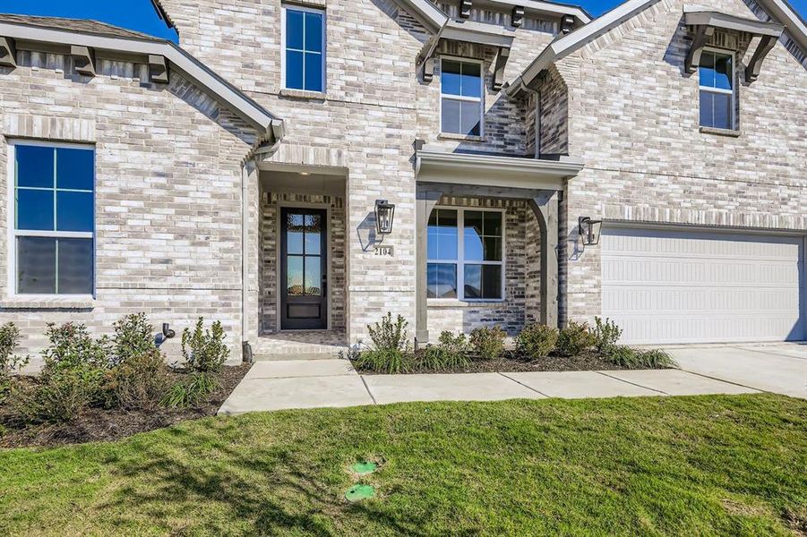 View of front of house with a garage, a front lawn, and brick siding View of front of house with a garage, a front lawn, and brick siding