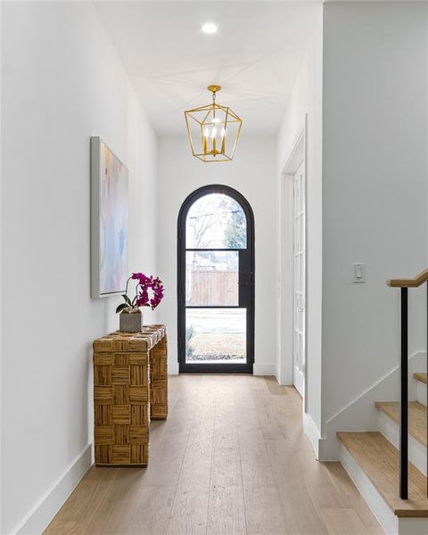 Entryway with wood-type flooring and a chandelier