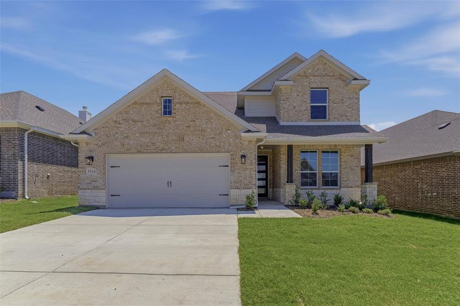 Two-story residence featuring a light brick facade with stone accents