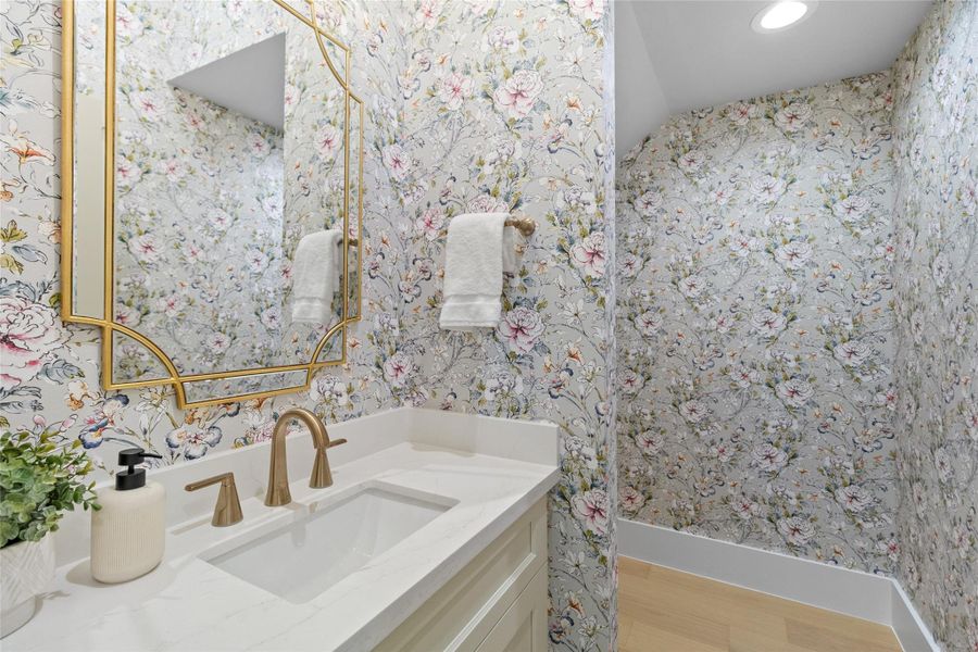 This powder bath makes a statement the moment you walk in. Floral wallpaper adds personality and warmth, paired with a sleek vanity, quartz counters, and elegant gold fixtures that elevate the space beyond ordinary—your guests will absolutely remember this one.
