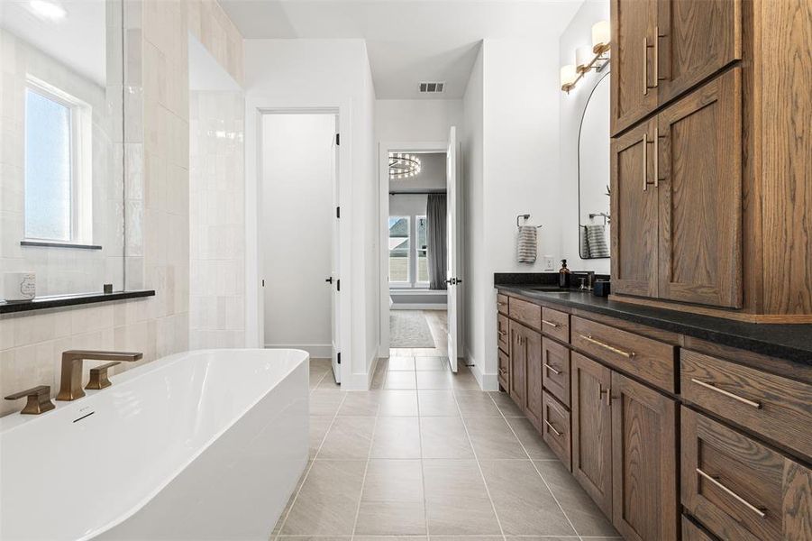 Full bath with a soaking tub, light tile patterned flooring, vanity, and tile walls Full bath with a soaking tub, light tile patterned flooring, vanity, and tile walls