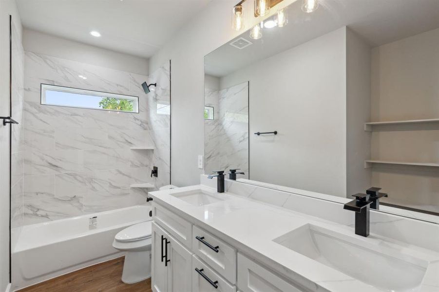 Full bathroom featuring tiled shower / bath, vanity, toilet, and hardwood / wood-style floors