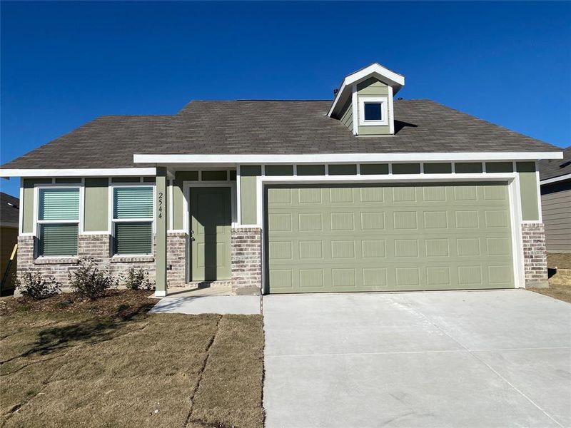 View of front of home featuring a garage, concrete driveway, and roof with shingles