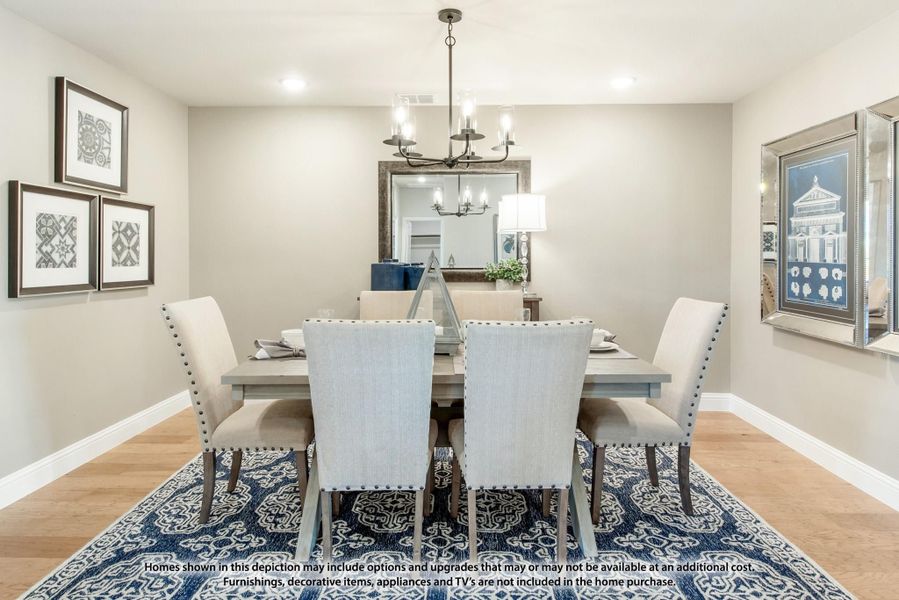 Dining room with six-chair table, chandelier, hardwood floors, and blue patterned area rug Dining room with six-chair table, chandelier, hardwood floors, and blue patterned area rug