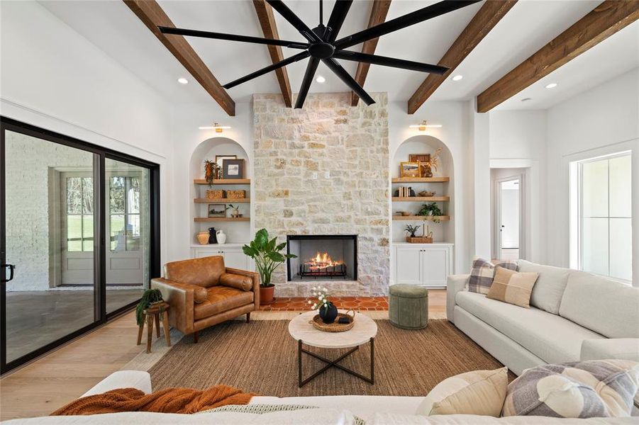 Living room featuring beamed ceiling, light wood finished floors, built in features, plenty of natural light, and recessed lighting