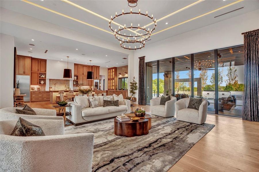 Living area with recessed lighting, light wood-style flooring, and a chandelier Living area with recessed lighting, light wood-style flooring, and a chandelier