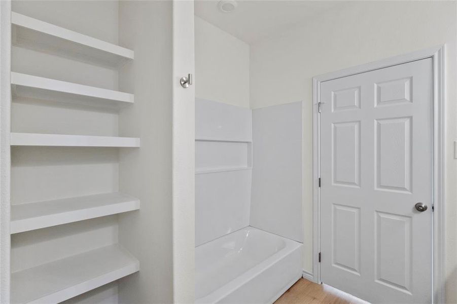 Full bath featuring shower / bath combination and light wood finished floors Full bath featuring shower / bath combination and light wood finished floors