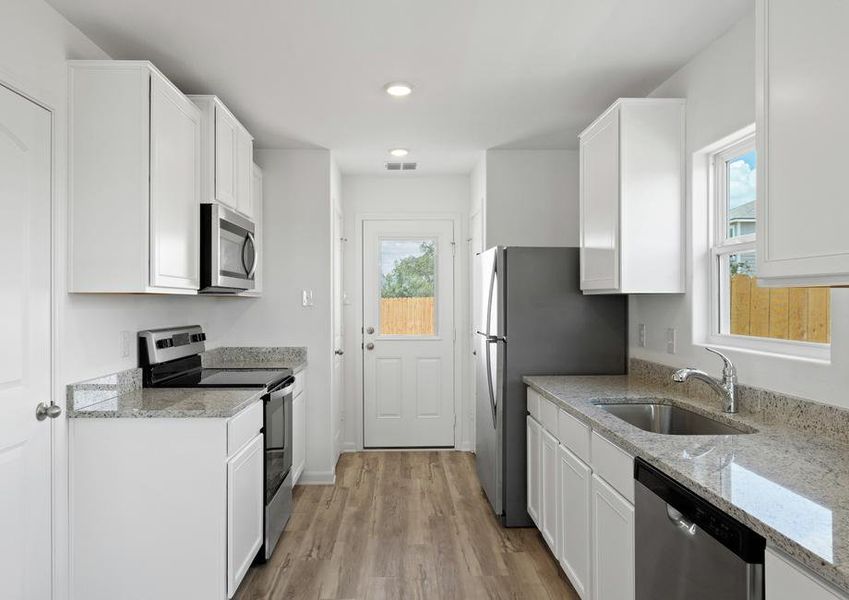 The kitchen is filled with stainless steel appliances and granite countertops