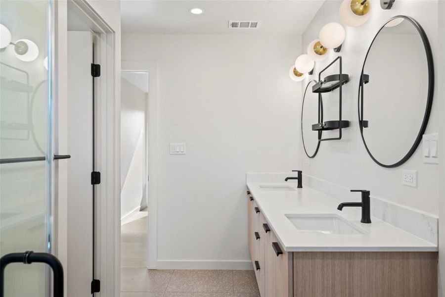 Bathroom featuring double vanity, a sink, visible vents, and baseboards