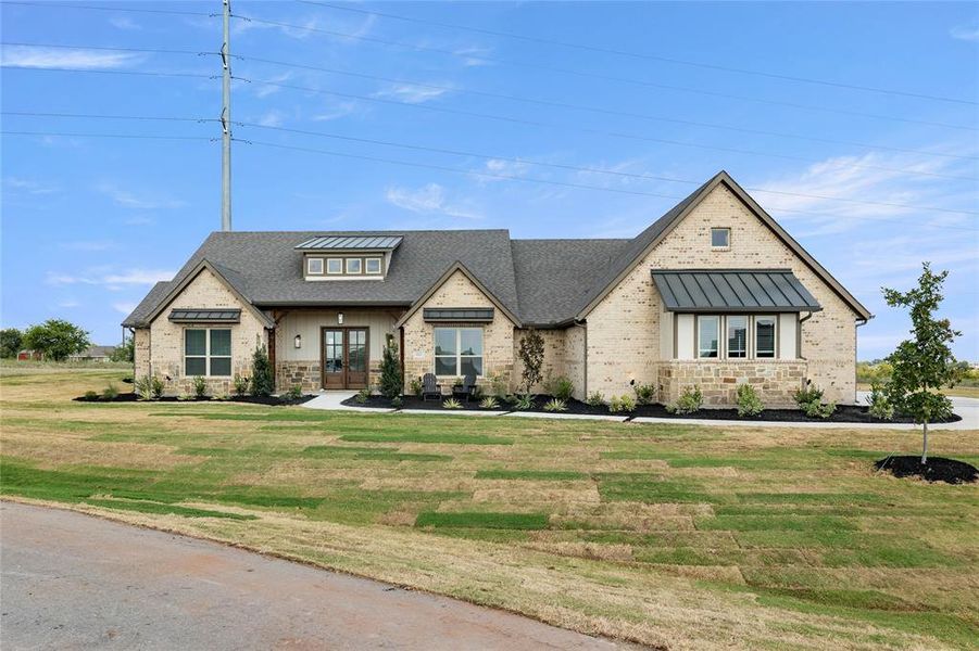 View of front of home featuring stone siding, a front lawn, a standing seam roof, and covered porch View of front of home featuring stone siding, a front lawn, a standing seam roof, and covered porch