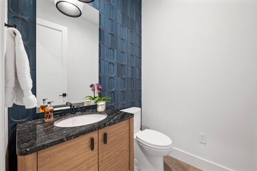 Bathroom featuring toilet, vanity, and baseboards Bathroom featuring toilet, vanity, and baseboards