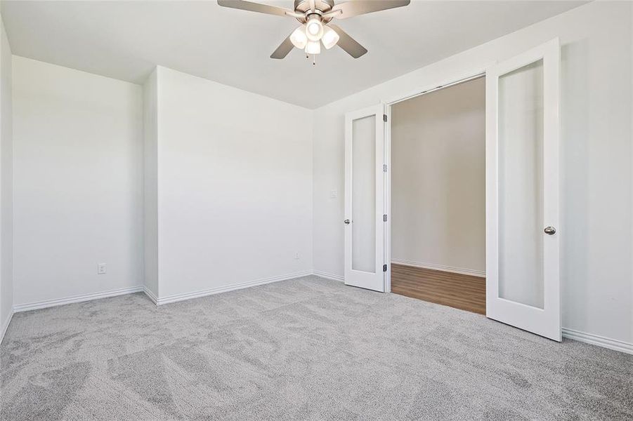 Unfurnished bedroom with french doors, light colored carpet, and ceiling fan