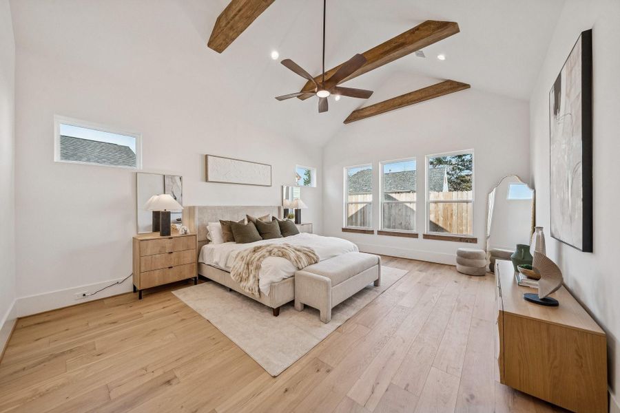 Stunning primary bedroom with 15 foot vaulted ceilings and wood accent beams.