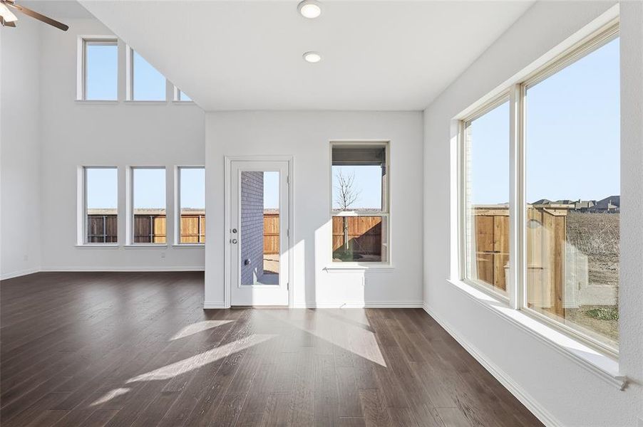 Open-concept interior featuring wood-finish flooring, high ceilings, and recessed lighting