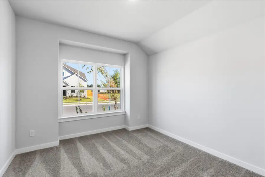 Carpeted spare room featuring baseboards