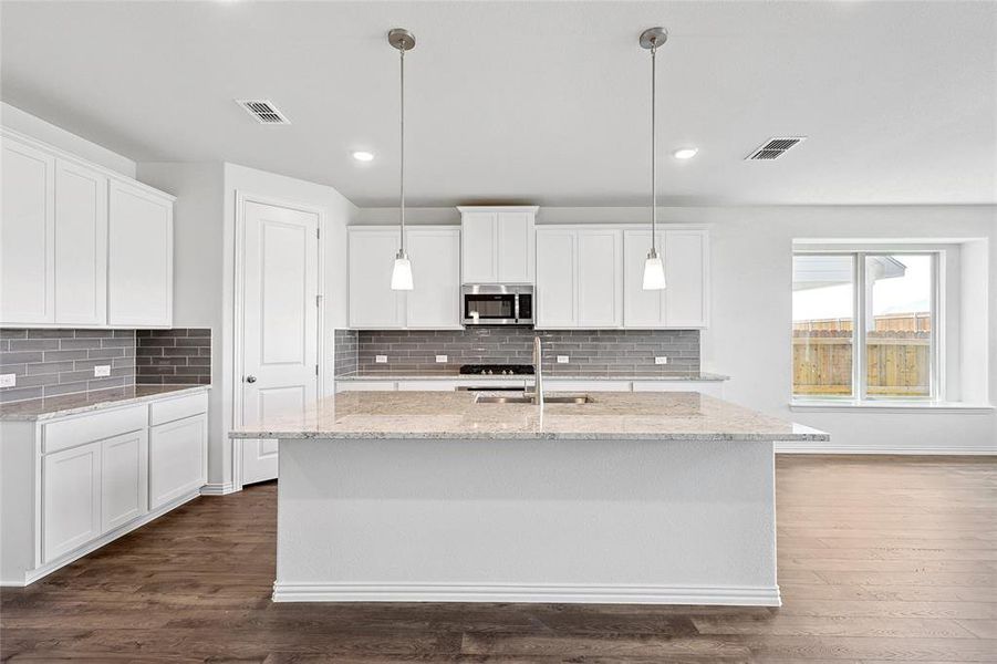 Kitchen with white cabinetry, decorative light fixtures, dark hardwood / wood-style flooring, and tasteful backsplash