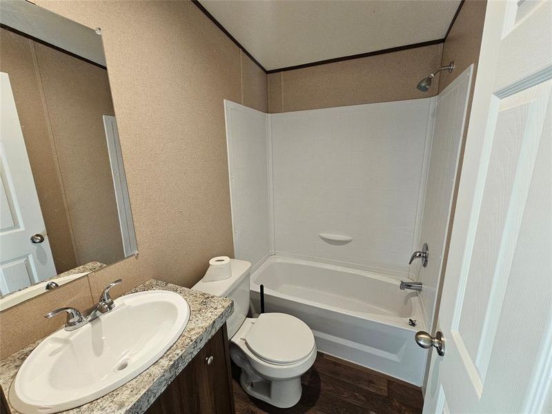 Bathroom with shower / washtub combination, vanity, and dark wood-type flooring Bathroom with shower / washtub combination, vanity, and dark wood-type flooring