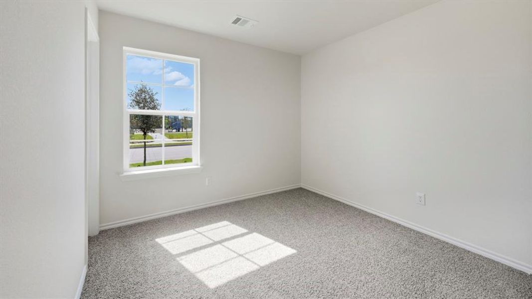 Empty room featuring light colored carpet and baseboards