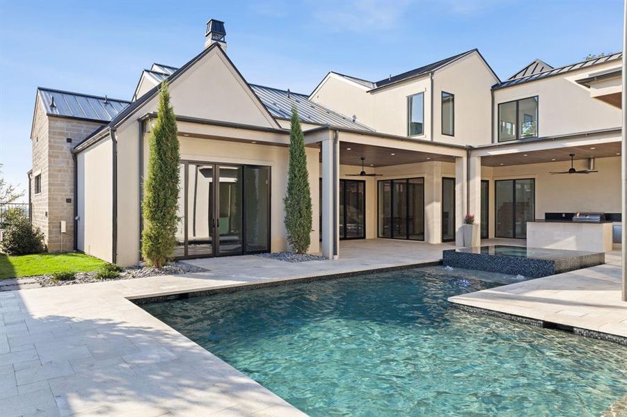 Back of property with ceiling fan, stucco siding, and exterior kitchen Back of property with ceiling fan, stucco siding, and exterior kitchen