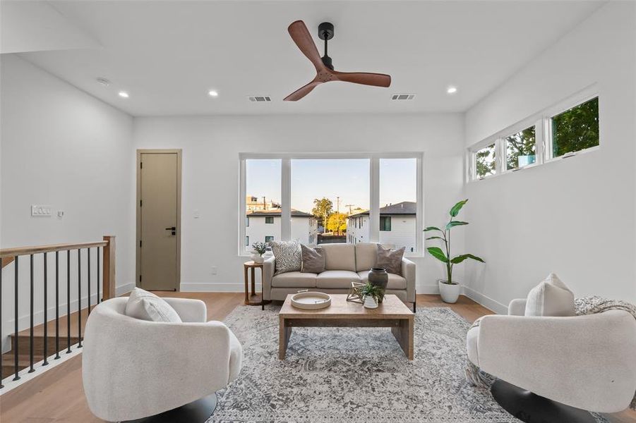 Living room featuring light wood-style floors, recessed lighting, and a ceiling fan