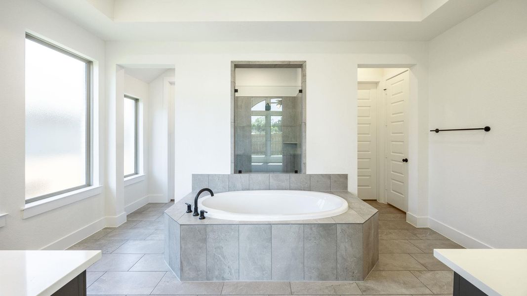 Full bathroom with a bath, tiled shower, vanity, and baseboards Full bathroom with a bath, tiled shower, vanity, and baseboards