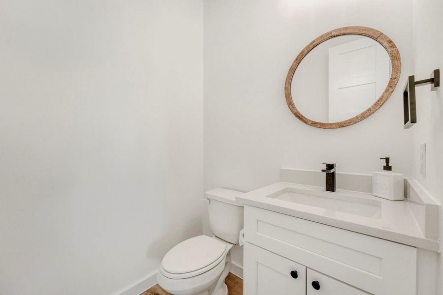 Half bathroom featuring vanity and toilet