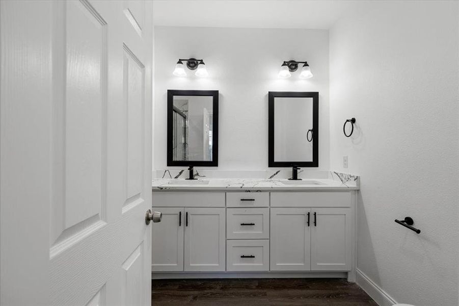Full bath with double vanity, dark wood-style flooring, and a shower with door Full bath with double vanity, dark wood-style flooring, and a shower with door