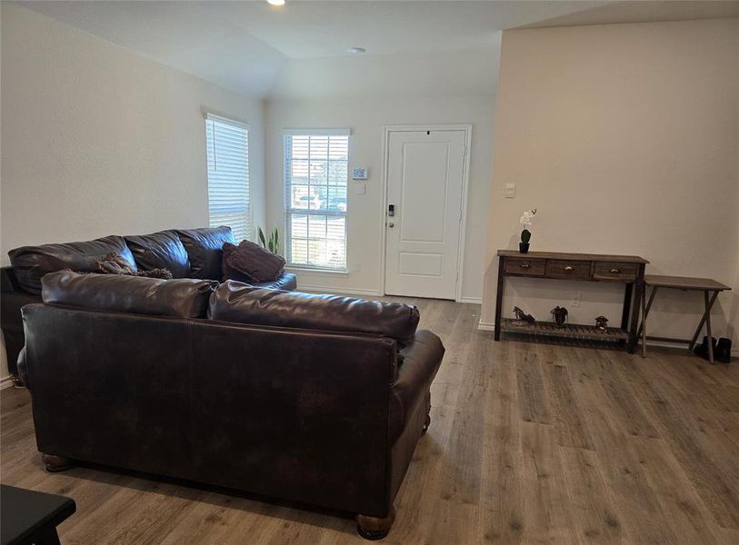 Living room with wood-type flooring and lofted ceiling