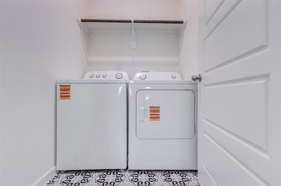 Practical utility room with washer and dryer included, patterned tile flooring, overhead hanging rod, and a clean, efficient layout. This dedicated laundry space keeps household tasks tucked away while offering convenience and function near the home’s private living areas, with room for essentials and everyday organization. Practical utility room with washer and dryer included, patterned tile flooring, overhead hanging rod, and a clean, efficient layout. This dedicated laundry space keeps household tasks tucked away while offering convenience and function near the home’s private living areas, with room for essentials and everyday organization.