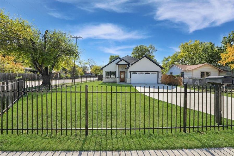 View of front of property with a fenced front yard, stucco siding, concrete driveway, and a garage